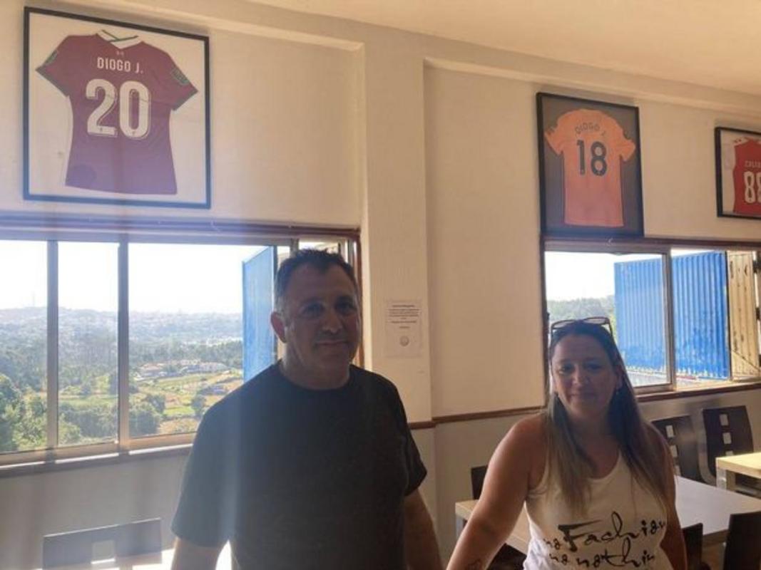 Carlos Sousa và Vanessa Marques trước hai chiếc áo do Diogo Jota tặng cho quán của họ