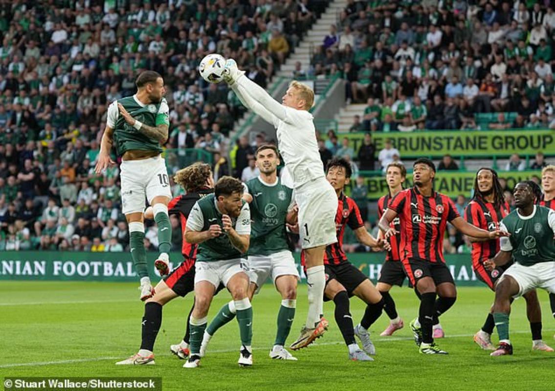 Thủ môn Jonas Lossl đấm bóng clerar trong khi Martin Boyle đe dọa trên không